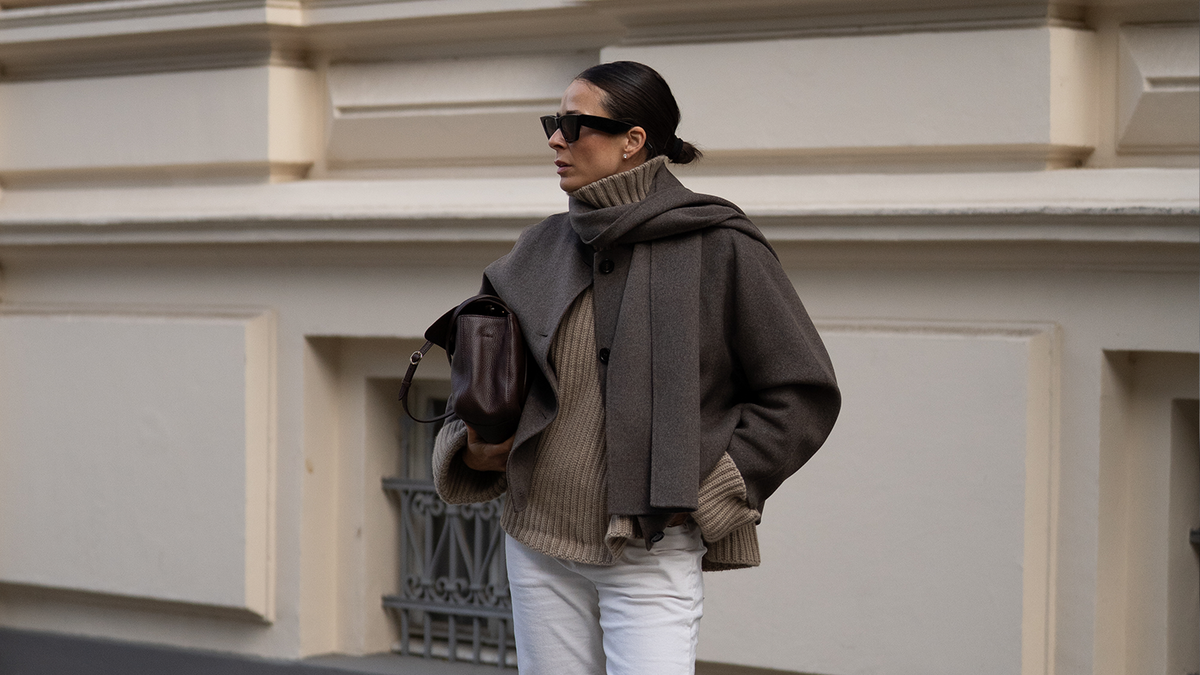 Outerwear Damen – Frau in grauer Wolljacke mit Schal, Strickpullover und brauner Ledertasche | C. Wirschke Düsseldorf