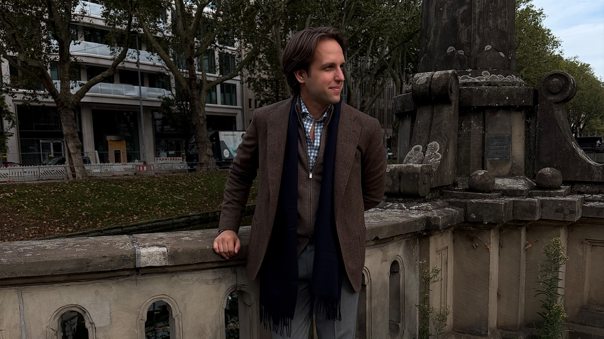 New Collection Herren – Herr in braunem Tweed-Sakko mit Schal und kariertem Hemd | C. Wirschke Düsseldorf