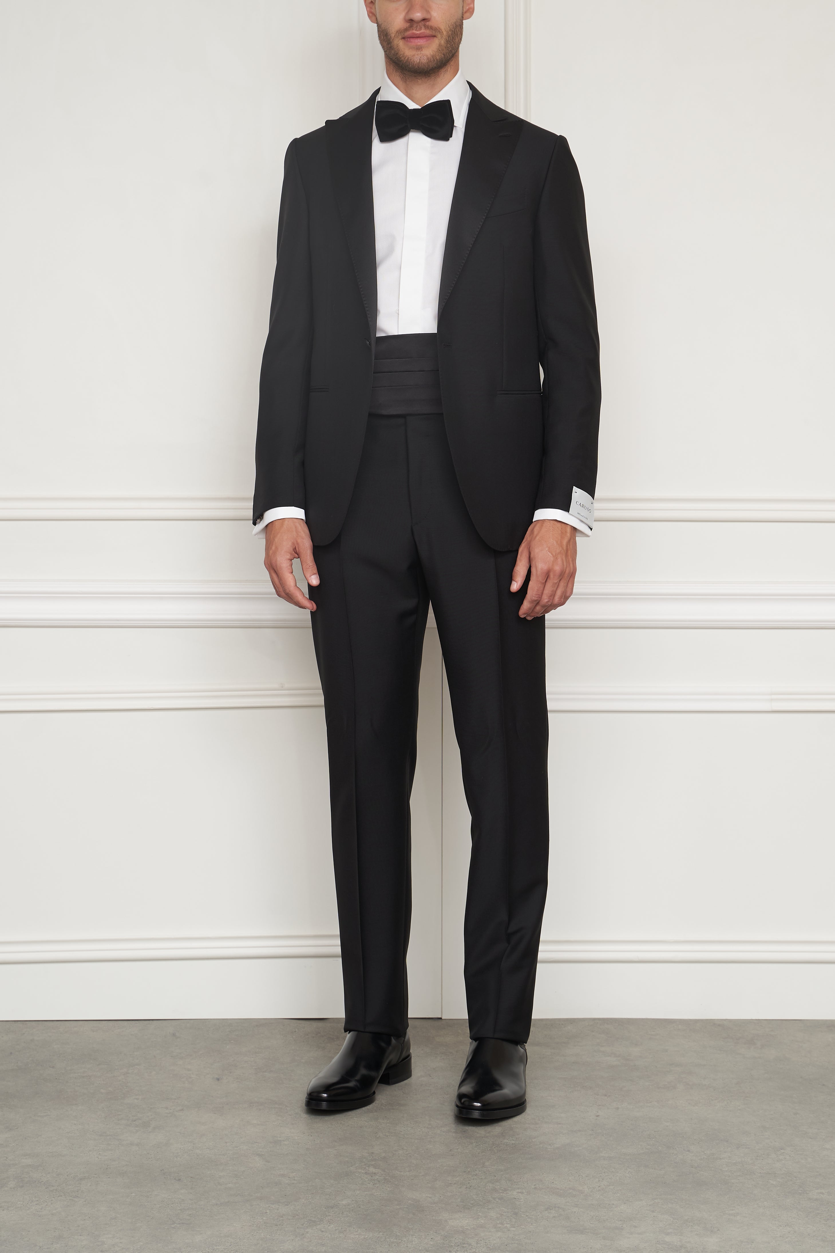Zweiterilig schwarzer Smoking von Caruso, eleganter Anzug mit schmalem Schnitt, perfekt für formelle Anlässe, auf weißem Hintergrund.