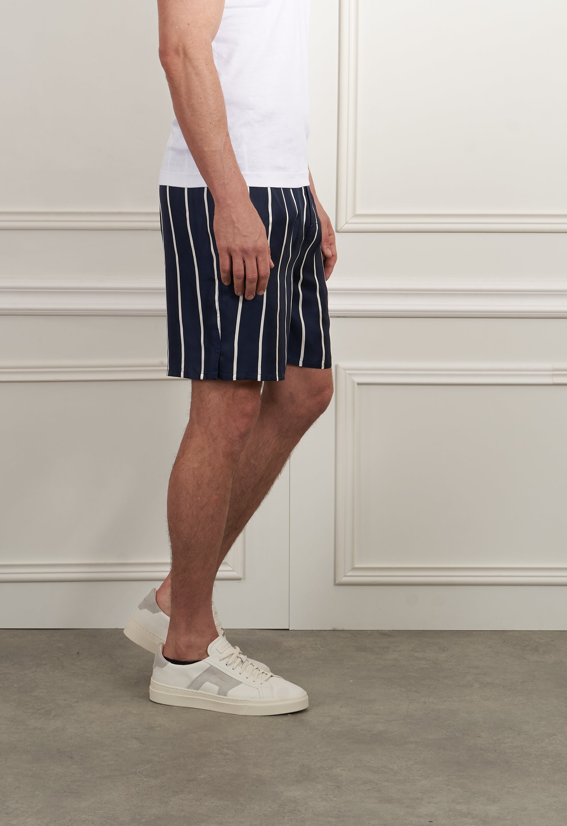 Marine-weiß gestreifte Bermuda-Shorts von AMI Paris, lässig kombiniert mit braunen Loafern, auf Bild sichtbar.