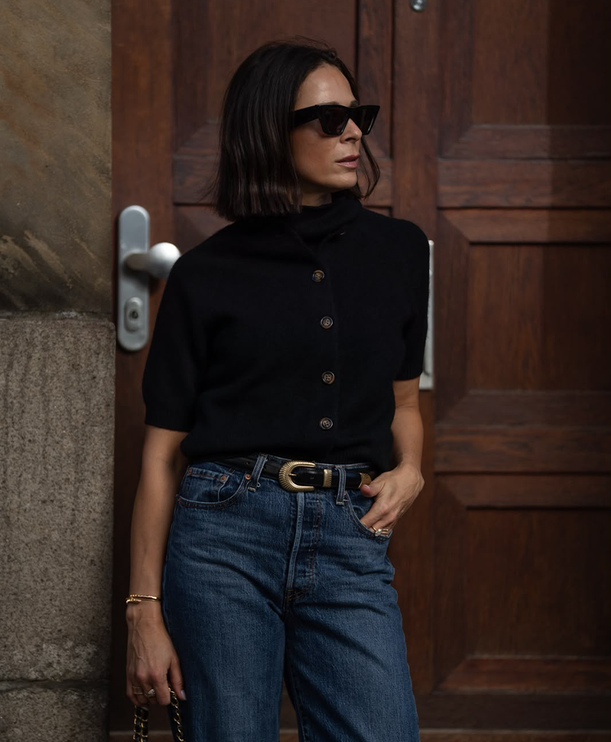 Anna V Berg x Patricia Wirschke – Frau in schwarzem Strickpolo mit Jeans | C. Wirschke Düsseldorf