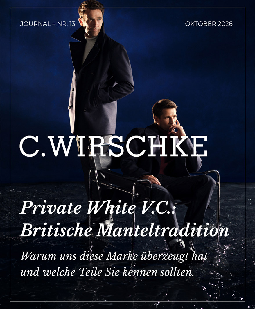 Journal Nr. 13: Private White V.C. – Britische Manteltradition. Zwei Männer in dunklen Mänteln vor nachtblauem Hintergrund, einer stehend mit grauem Rollkragenpullover, einer sitzend auf einem Freischwinger